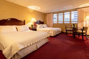El Rey Palace Hotel في لاباز: غرفة فندقية بسريرين وطاولة