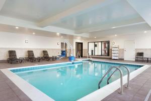 una piscina en un hotel con sillas y mesas en Hilton Garden Inn Medford, en Medford