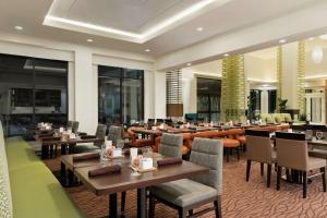 a restaurant with tables and chairs in a room at Hilton Garden Inn Medford in Medford
