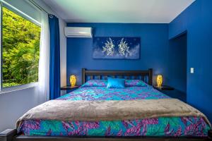 a blue bedroom with a bed and a window at Casa Sol in Carrillo