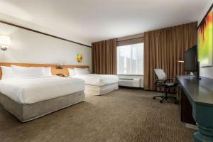 a hotel room with two beds and a desk at Hilton Garden Inn Medford in Medford