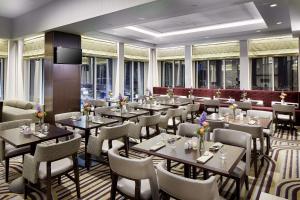 um restaurante com mesas, cadeiras e janelas em Hilton Garden Inn Roslyn em Roslyn