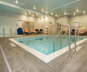 a large swimming pool with chairs and a table at Hampton Inn and Suites Minneapolis University Area, MN in Minneapolis