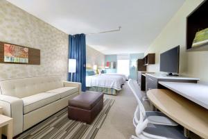 Home2 Suites By Hilton Prattville في براتفيل: غرفة في الفندق مع أريكة وسرير