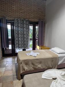 a hotel room with two beds and a window at Pousada Solar dos Lençóis in Barreirinhas