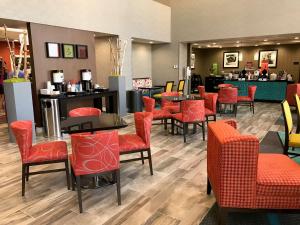 a restaurant with red chairs and tables and a bar at Hampton Inn & Suites-Moore in Moore