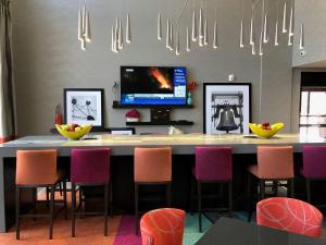 a kitchen with a bar with chairs and a tv at Hampton Inn & Suites-Moore in Moore
