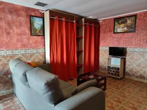 salon z kanapą i czerwonymi zasłonami w obiekcie Apartamentos Matraca w mieście Villamediana de Iregua