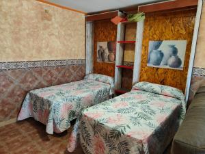 Pokój z 2 łóżkami i kanapą w obiekcie Apartamentos Matraca w mieście Villamediana de Iregua