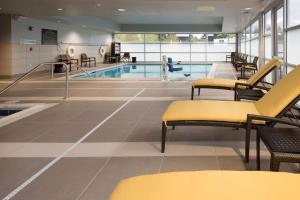 uma piscina com cadeiras amarelas e uma piscina em Hampton Inn & Suites Seattle/Redmond Wa em Redmond