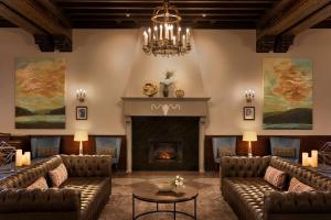 a living room with couches and a fireplace at Hotel Saranac, Curio Collection By Hilton in Saranac Lake