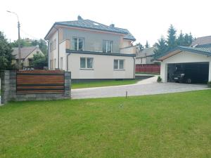 a large white house with a garage and a driveway at Apartament 4U - Azyl Arkadia in Suwałki