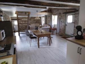 La Roche-lʼAbeille的住宿－Reids Retreat，厨房以及带木桌和椅子的客厅。