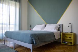 a bedroom with a bed with a yellow night stand at Ca Emma - Homy Home in Turin