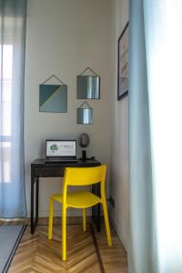 a yellow chair sitting next to a desk with a laptop at Ca Emma - Homy Home in Turin +39 photos