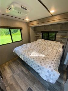 a bed in the middle of a bedroom in a trailer at Eden Farm RV Minutes from Salisbury in Eden