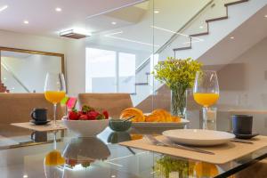 een tafel met een fruitschaal en twee glazen sinaasappelsap bij Tiz house in Funchal
