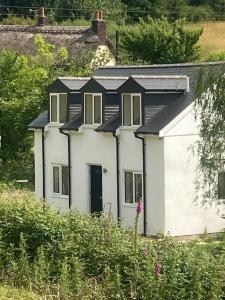 una casa blanca con techo negro en Ruby's Retreat! Farm Stay! North devon! Beaches and Exmoor!, en Barnstaple