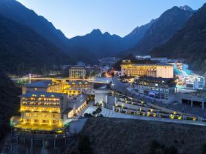 uma vista para uma cidade à noite com montanhas em Hilton Sanqingshan Resort em Shangrao