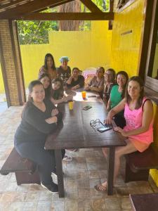 een groep mensen die aan een tafel zitten bij Pousada Solar dos Lençóis in Barreirinhas
