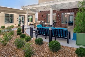 a patio with blue chairs under a pergola at Homewood Suites by Hilton St. Louis Westport in Maryland Heights