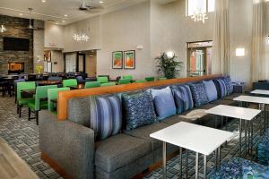 a restaurant with a couch and tables and chairs at Homewood Suites by Hilton St. Louis Westport in Maryland Heights
