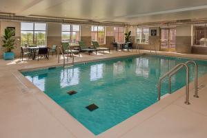 a large swimming pool with blue water in a building at Homewood Suites by Hilton St. Louis Westport in Maryland Heights