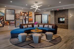 a living room with a blue couch and a table at Homewood Suites by Hilton St. Louis Westport in Maryland Heights