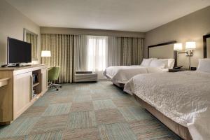 a hotel room with two beds and a flat screen tv at Hampton Inn Yemassee/Point South, Sc in Yemassee