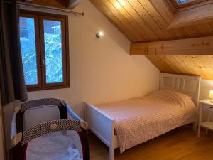 Habitación pequeña con cama y ventana en CHALET 16 PERS PROCHE DES PISTES, en Vallouise