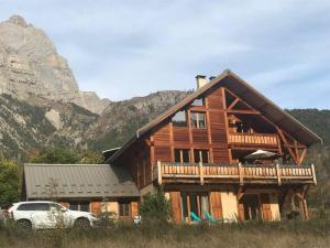 una casa de madera con un coche aparcado delante de ella en CHALET 16 PERS PROCHE DES PISTES, en Vallouise