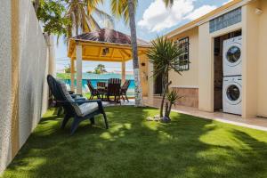 a yard with a bench and a house at Blue Sky Residence Aruba in Savaneta