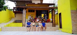 un gruppo di persone seduti sui gradini di un edificio di Pousada Solar dos Lençóis a Barreirinhas