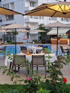 a restaurant with tables and umbrellas and a pool at Villa Pearl Adriatic Coast 3 in Golem