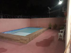 a large swimming pool in a patio at night at Hospedaria Salém in Soure