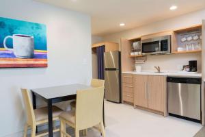 a kitchen with a table and chairs in a room at Home2 Suites By Hilton Nokomis in Nokomis