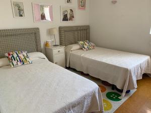 a bedroom with two beds and a table with a lamp at Vivienda en Combarro in Combarro
