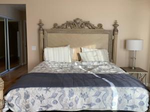 a bedroom with a bed with a blue and white comforter at Pacific Breeze Right Next to Huntington Beach Pier! Steps from Beach!! in Huntington Beach