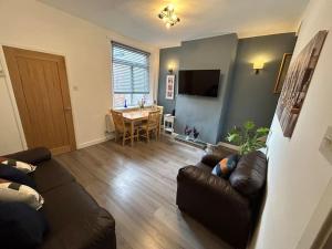 a living room with a couch and a table at Spacious homely 3 bed property in Newcastle under Lyme