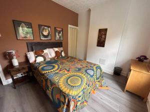 um quarto com uma cama com um edredão colorido em Spacious homely 3 bed property em Newcastle under Lyme