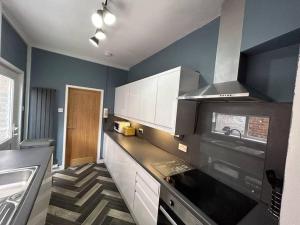 a kitchen with a sink and a stove top oven at Spacious homely 3 bed property in Newcastle under Lyme