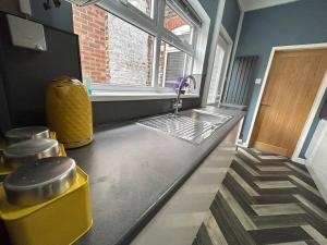 a kitchen counter with a sink and a window at Spacious homely 3 bed property in Newcastle under Lyme