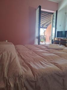 a bedroom with two beds and a tv and a window at Agriturismo Ca 'd Tistu in San Benedetto Belbo