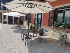 San Benedetto Belbo的住宿－Agriturismo Ca 'd Tistu，庭院内桌椅和遮阳伞