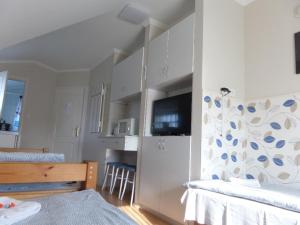 a room with two beds and a kitchen at Karneol Apartmanház Cserkeszőlő in Cserkeszőlő