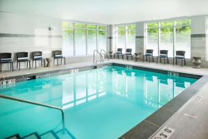 a swimming pool with chairs in a building at Hampton Inn & Suites Bridgewater, NJ in Bridgewater