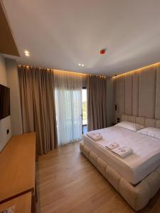 a bedroom with a large white bed and a television at Absolute Hotel Ksamil in Ksamil