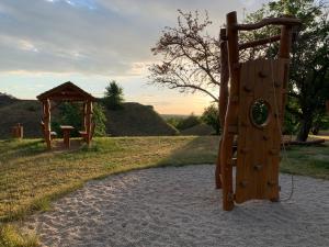 a wooden playground with a gazebo in a field at Apartmány na Vršku in Pilsen
