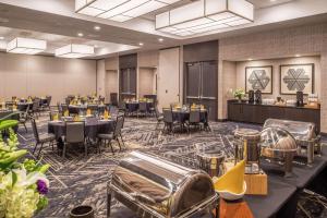 une salle de banquet avec des tables et des chaises ainsi qu'un bar dans l'établissement Doubletree By Hilton Lafayette East, à Lafayette