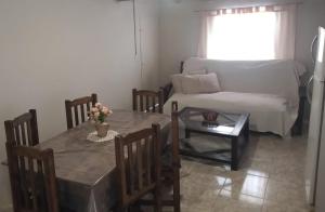 uma sala de estar com uma mesa e um sofá em IAUE EL HOGAR, una habitacion cocina,baño, estacionamiento compartido y patio em Luján de Cuyo